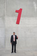 Hispanic businessman holding balloon shaped like number 1
