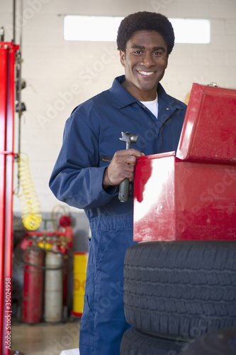 Photo: Mixed race mechanic working in auto repair shop Mixed race mechanic working in auto repair shop