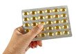 Hand with healthy omega oil capsule packet over white Hand with healthy omega oil capsule packet over white