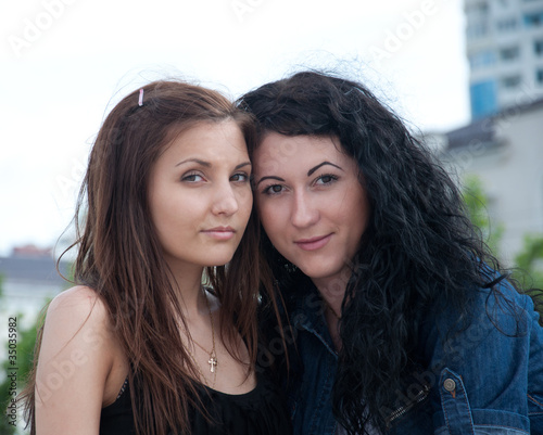 Photo: Two girls friends at city background Two girls friends at city background