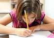 Foto: Small girl working on her school project at home Small girl working on her school project at home