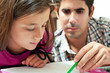 Girl and her young latin father working on a school project