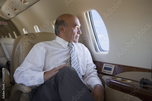 Photo: Hispanic businessman on private jet Hispanic businessman on private jet