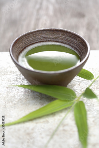 Photo: Close up of Japanese green Matcha tea and bamboo sprig Close up of Japanese green Matcha tea and bamboo sprig