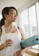 Foto: Smiling mixed race teenage girl holding yoga mat and water bottle Smiling mixed race teenage girl holding yoga mat and water bottle