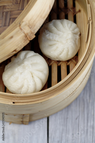 Photo: Close up of steamed dim sum pork buns in bamboo basket Close up of steamed dim sum pork buns in bamboo basket