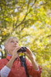 Caucasian woman using binoculars outdoors