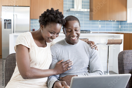 Photo: Black couple hugging and using laptop Black couple hugging and using laptop