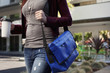 Caucasian woman walking with messenger bag and coffee
