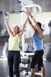 Woman exercising in health club with trainer