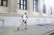 African American man running on city sidewalk