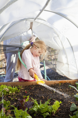 Photo: Caucasian girl watering garden Caucasian girl watering garden