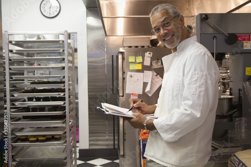 Foto: African American small business owner working in bakery kitchen African American small business owner working in bakery kitchen