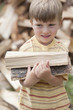 Caucasian boy carrying firewood
