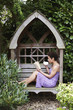 Mixed race woman reading book in backyard