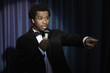 Serious Black man in tuxedo holding microphone