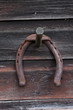 Rusted horseshoe hanging on wooden wall
