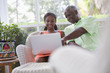 Black grandfather looking at laptop with granddaughter