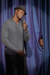 Black boy watching man singing into microphone