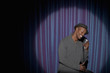Smiling Black man singing into microphone