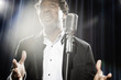 Smiling Black man in tuxedo standing at microphone