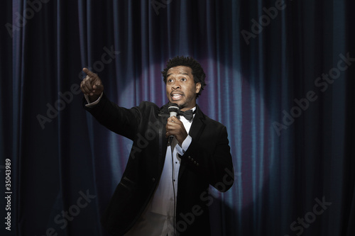 Photo: Black man in tuxedo holding microphone Black man in tuxedo holding microphone