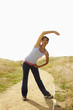 Mixed race woman stretching on remote path