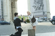 Caucasian man taking photograph of girlfriend near Arc de Triomphe