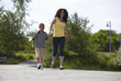 Black mother and son walking down road together
