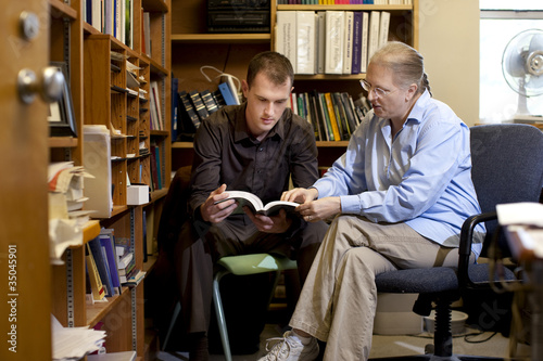 Photo: Teacher talking with student about book Teacher talking with student about book