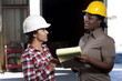 Supervisor talking to sanitation worker in recycling plant