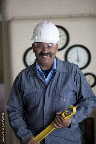 Foto: Hispanic worker in hard-hat holding tool Hispanic worker in hard-hat holding tool