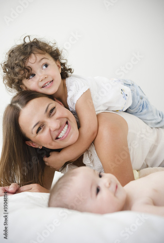 Foto: Mother playing on bed with daughters Mother playing on bed with daughters
