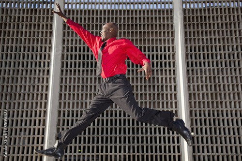 Photo: African American businessman jumping in mid-air African American businessman jumping in mid-air
