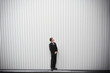 Uncertain groom standing near wall