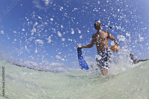 Photo: Hispanic man walking in water with snorkel gear Hispanic man walking in water with snorkel gear