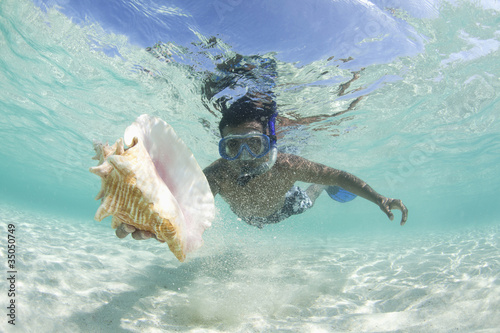 Photo: Hispanic man snorkeling and finding shell Hispanic man snorkeling and finding shell