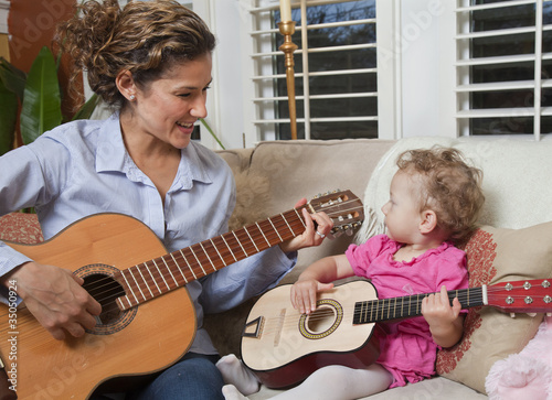 Photo: Hispanic mother playing guitar with daughter Hispanic mother playing guitar with daughter