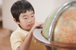Korean boy looking at globe