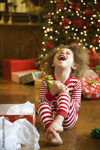 Photo: Excited mixed race boy opening Christmas gift Excited mixed race boy opening Christmas gift