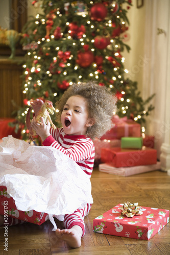 Photo: Mixed race boy playing with Christmas gift Mixed race boy playing with Christmas gift