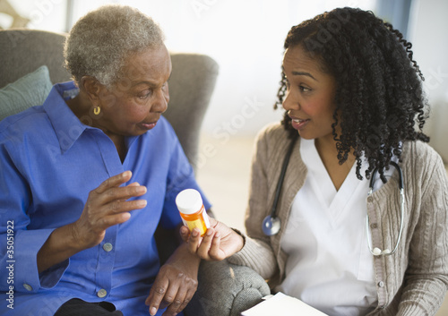Photo: Nurse explaining medication to woman Nurse explaining medication to woman