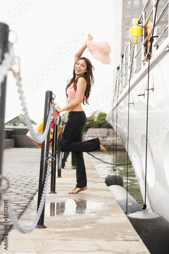 Foto: Hispanic woman standing on pier near boat Hispanic woman standing on pier near boat