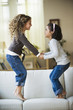 Mixed race girls jumping on sofa