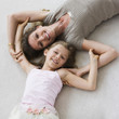 Caucasian mother and daughter laying on floor