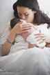 Mother in hospital bed holding newborn baby girl