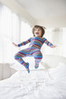 Caucasian boy jumping on bed