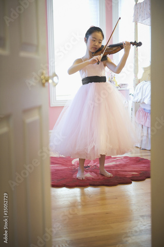 Photo: Asian girl in elegant dress playing violin Asian girl in elegant dress playing violin