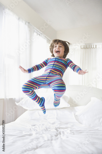 Photo: Caucasian boy jumping on bed Caucasian boy jumping on bed
