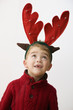 Caucasian boy with reindeer antlers headband on his head